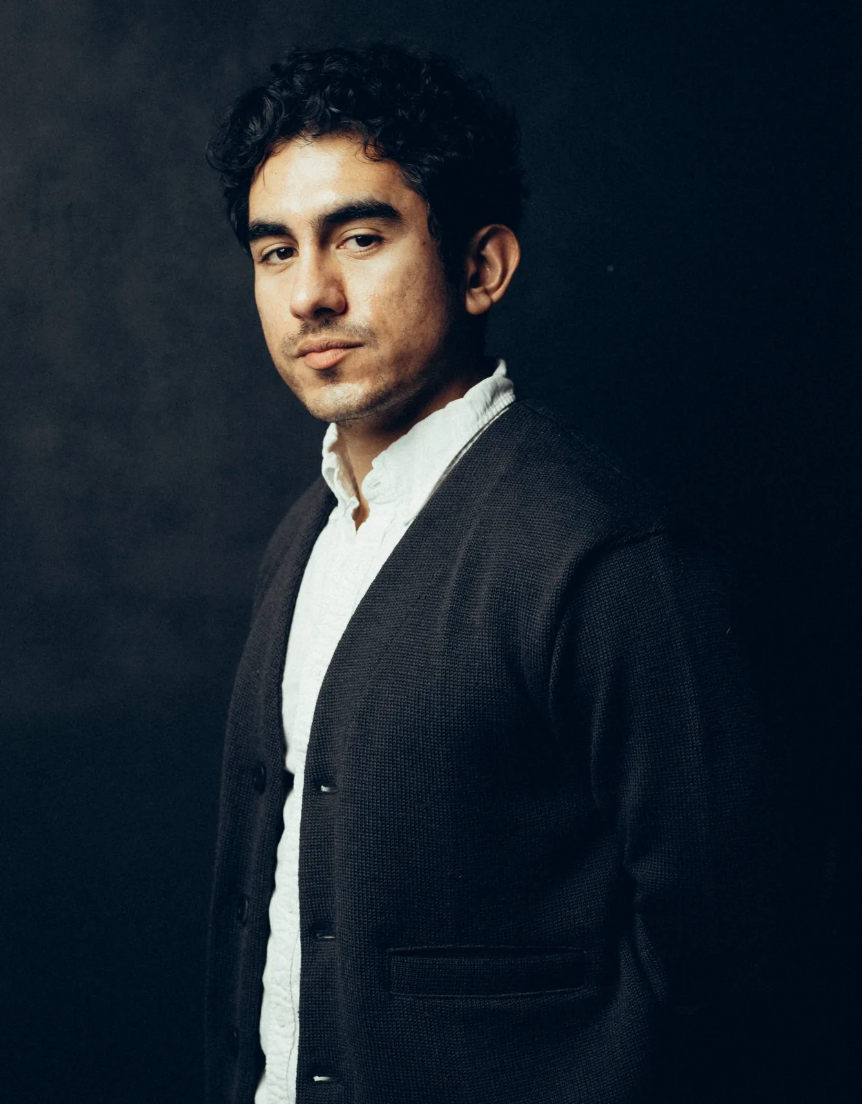 Lenny Ramos profile portrait, cardigan, studio background
