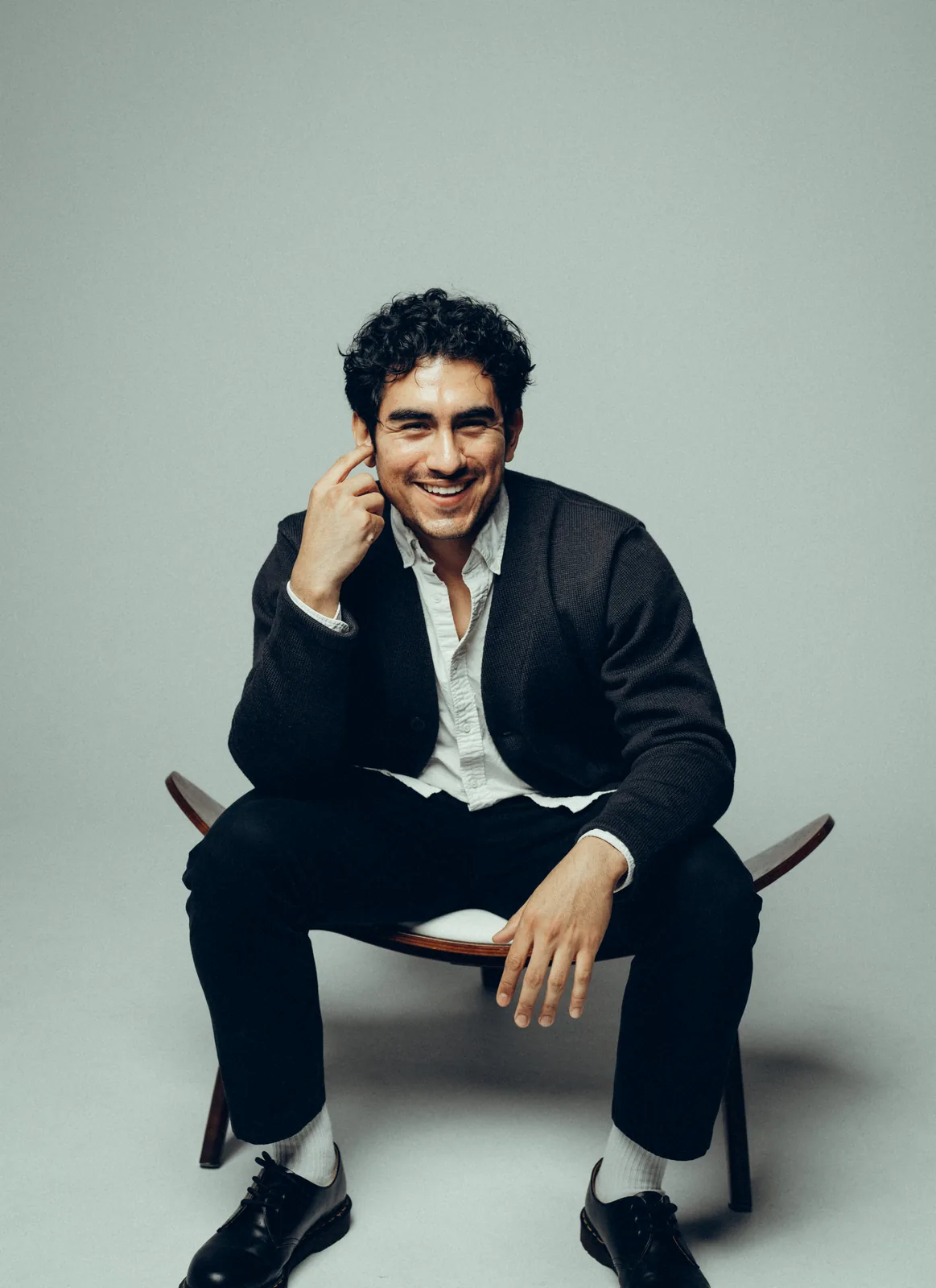 Lenny Ramos seated portrait, smiling, in a cardigan