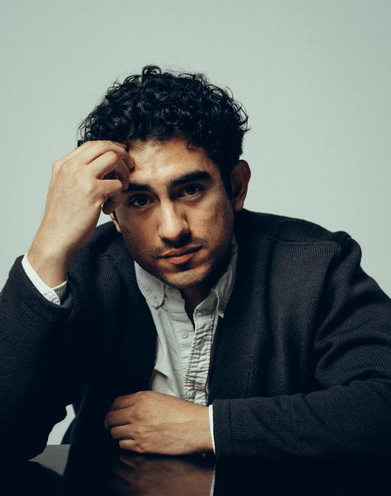 Lenny Ramos portrait, serious expression, in a cardigan